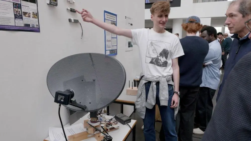 Dylan showcases his innovative radio telescope to industry professionals visiting the engineering poster day