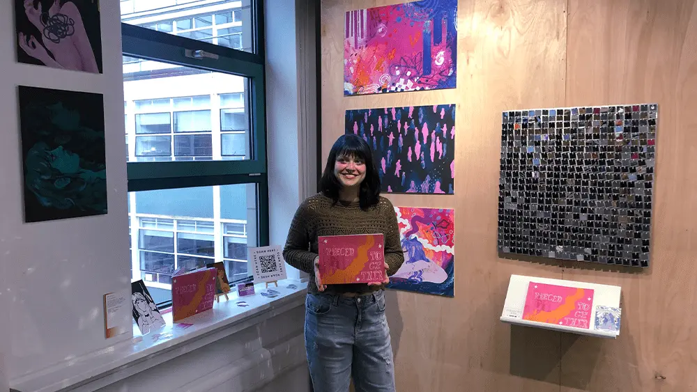 Emily Chandler stood with her artwork on campus at Southampton Solent University.