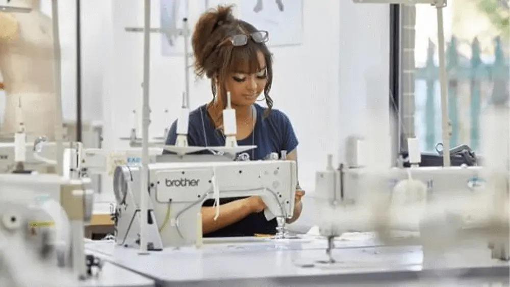 A female student working at a sewing machine.