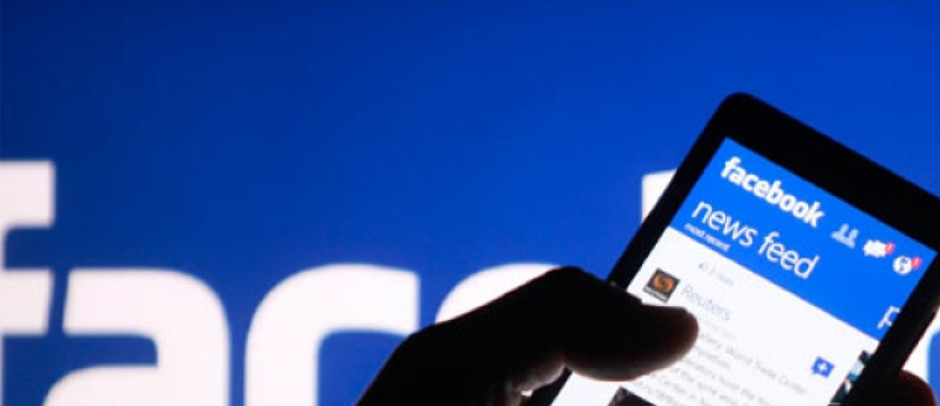 A phone with the Facebook news feed