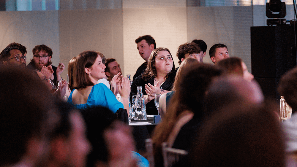 Students sat at tables clapping at the Film and Media Awards.