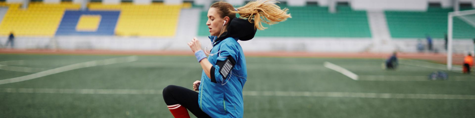 A female athlete warming up in an empty stadium