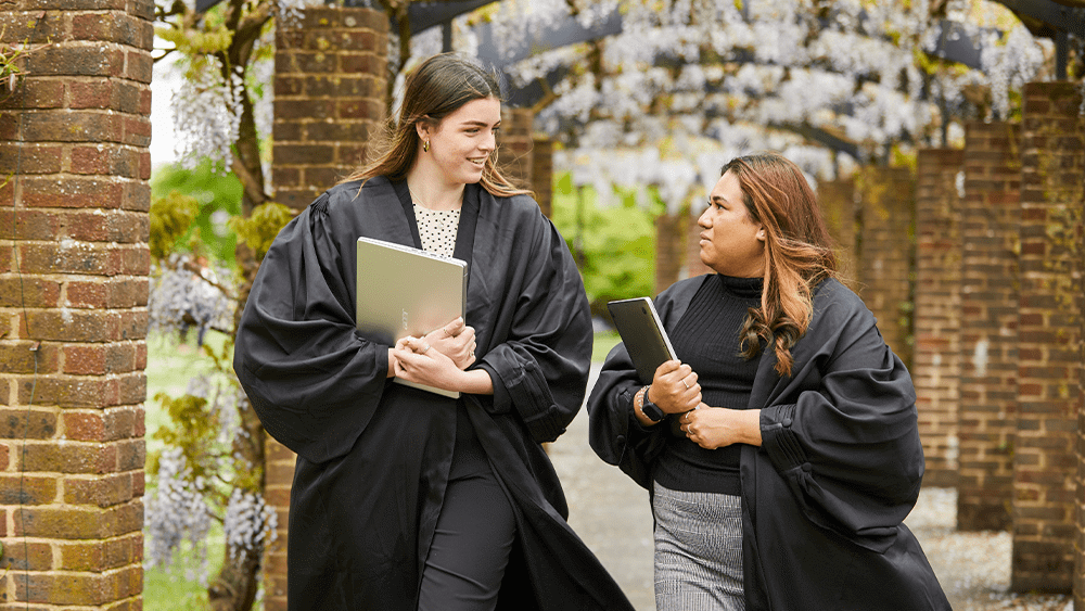 Two female law students walking through a park.