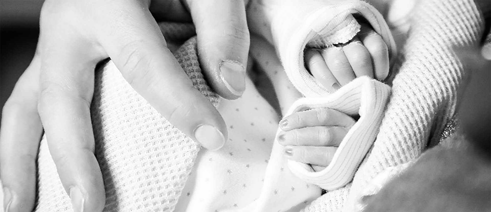 Hands of a parent holding their baby