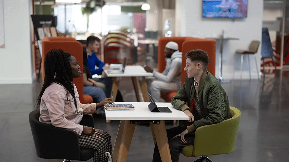Two students sat together at a table in The Spark