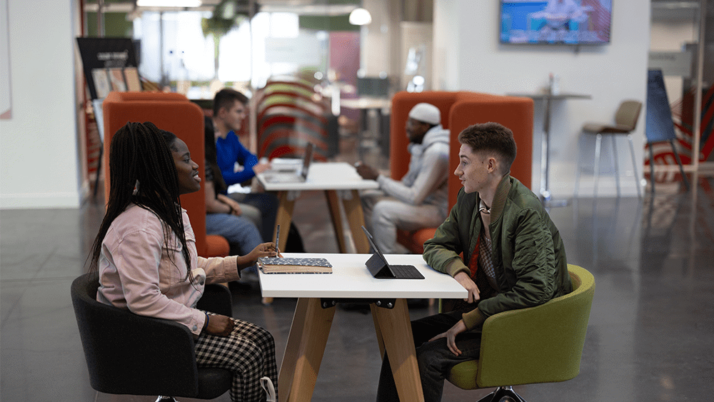 Two students sat together at a table in The Spark