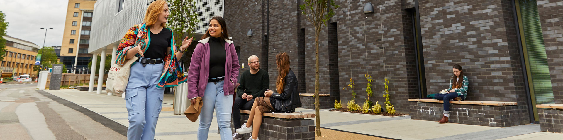 Two female students walking outside the sports complex