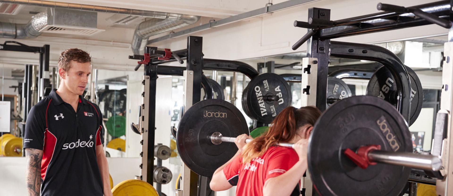 Solent sport gym trainer and a client lifting weights