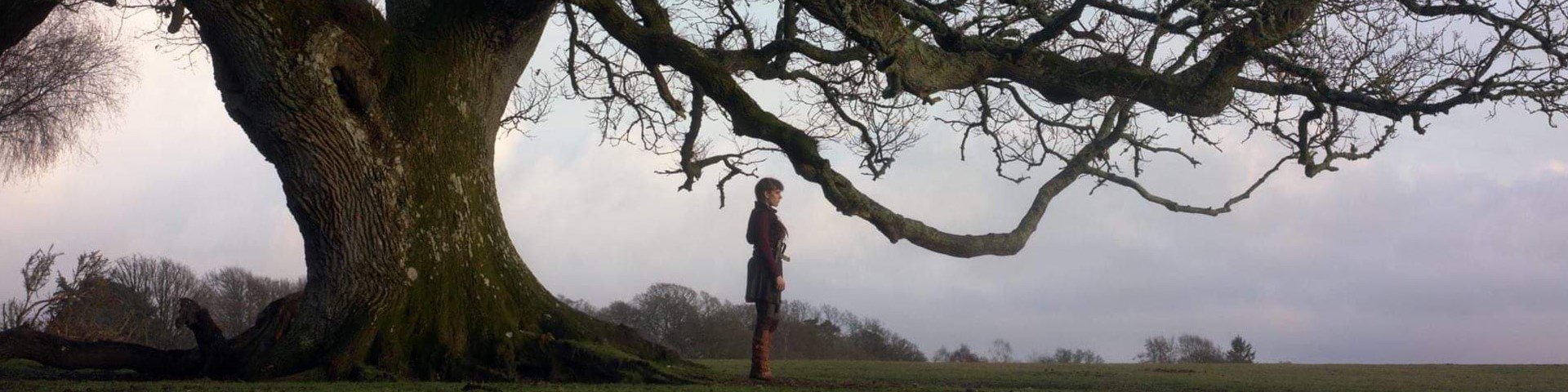 A still from Oathbreaker of a person standing under a tree
