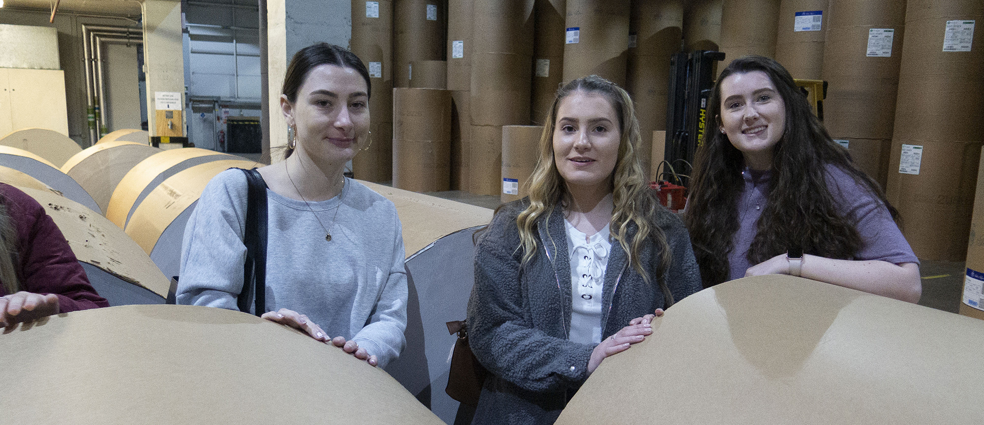 Three students among reams of paper