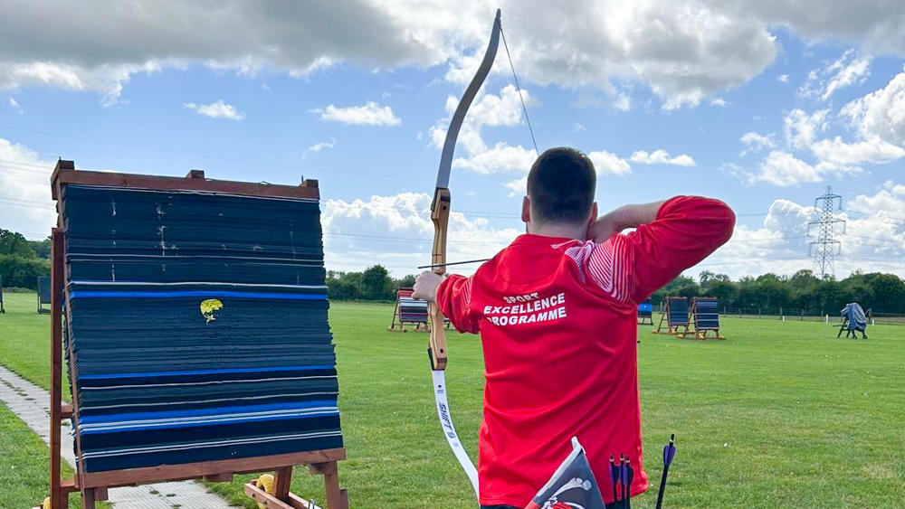 Rob draws his bow in practice