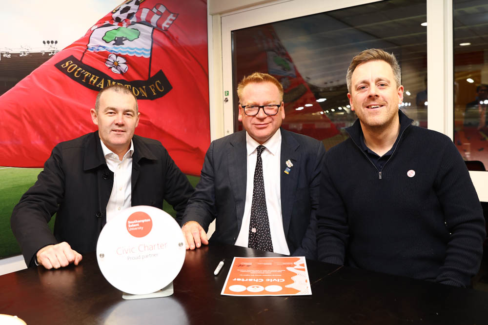 Professor James Knowles signs the charter with Phil Parsons and Sam Fulling