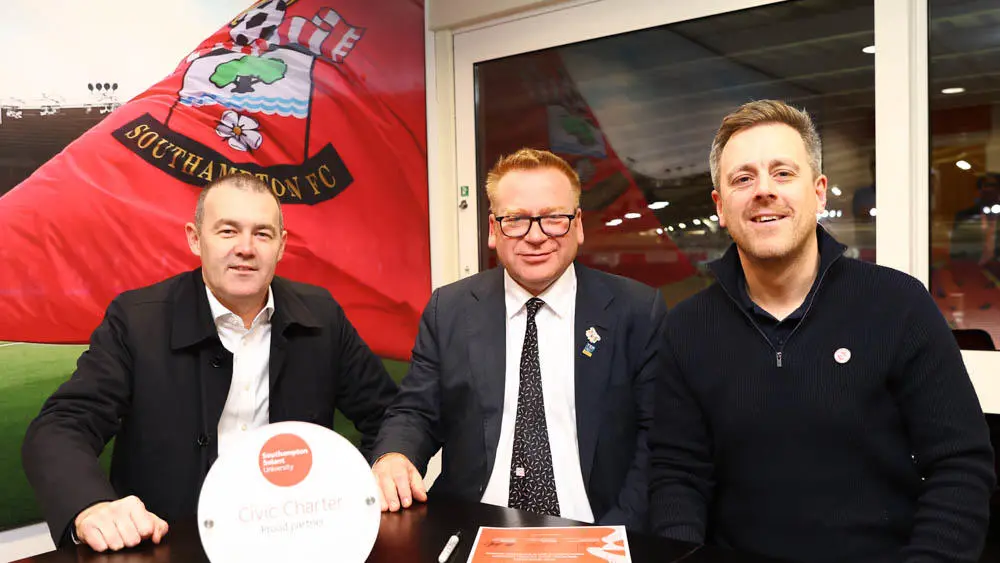 Professor James Knowles signs the charter with Phil Parsons and Sam Fulling