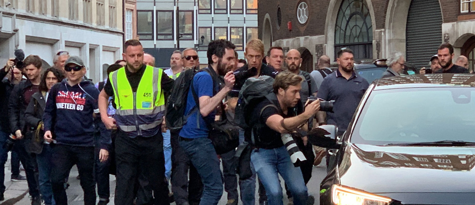 A security guard surrounded by photographers