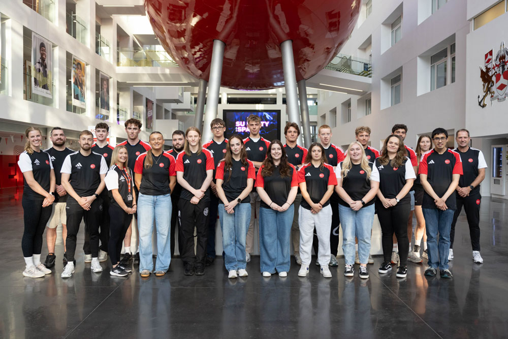 Student athletes in a group photo under the pod 