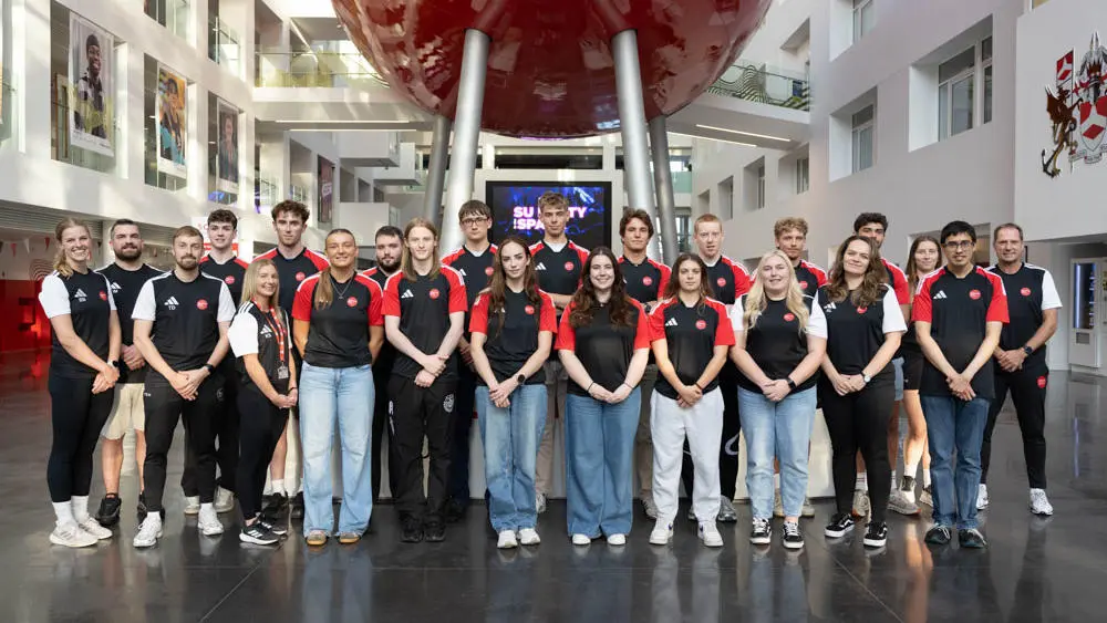 Student athletes in a group photo under the pod