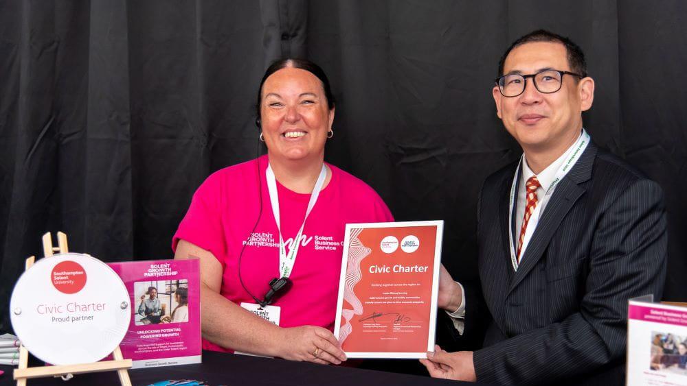 (L-R) Jodi Fair holding the signed Civic Charter with Professor Andy Chan