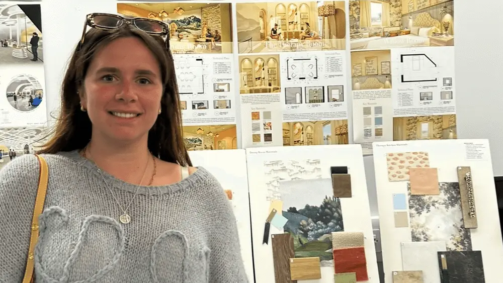 Sophie Criddle in front of a display of her Final Major Project.