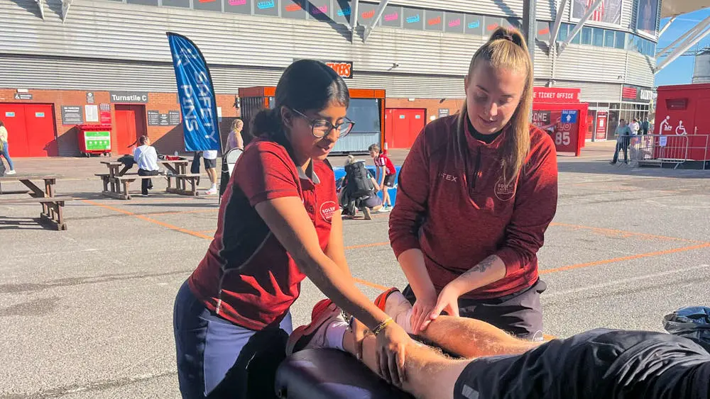 Sports therapy students supporting a runner