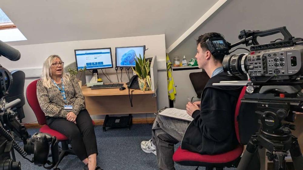 A student off camera interviewing on the receptionists for the documentary