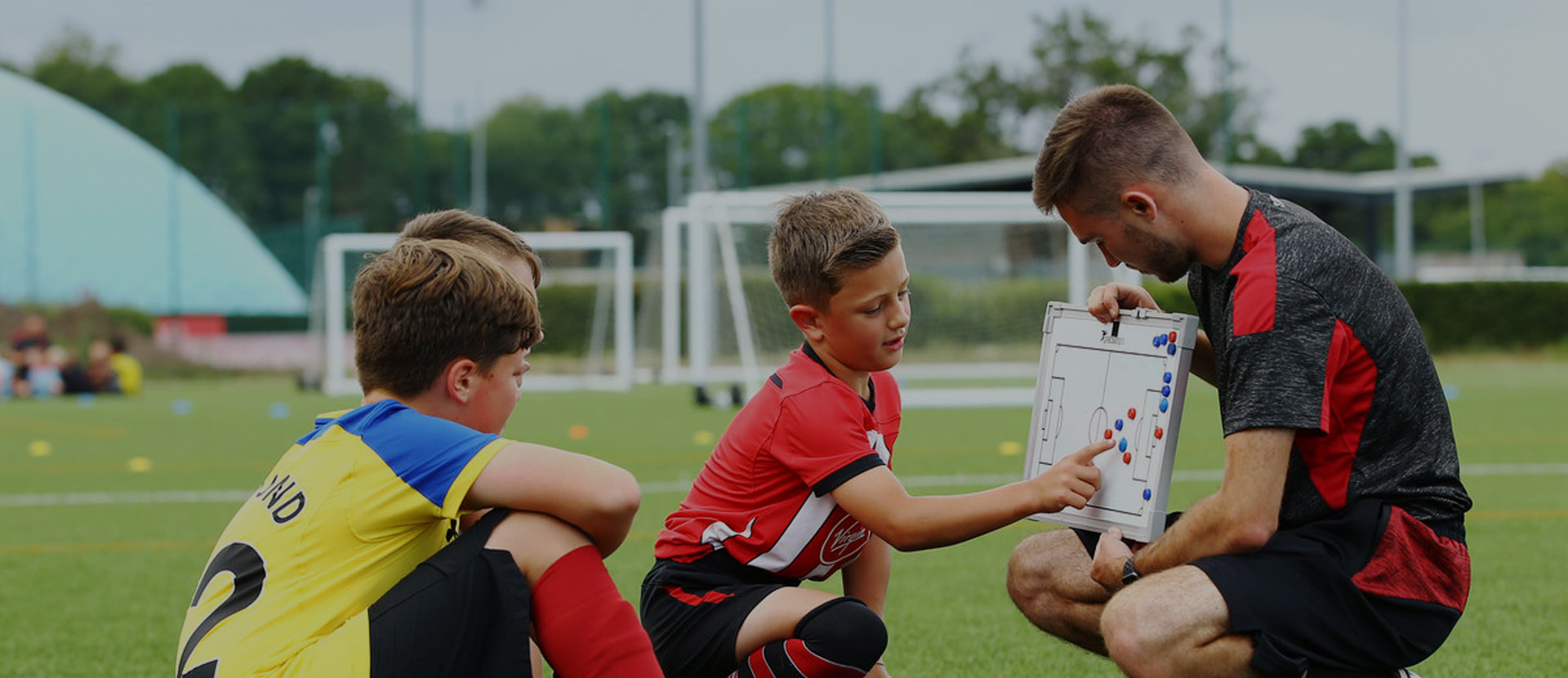 Fraser Ford looking at football formations with some young players at a Saints Foundation event