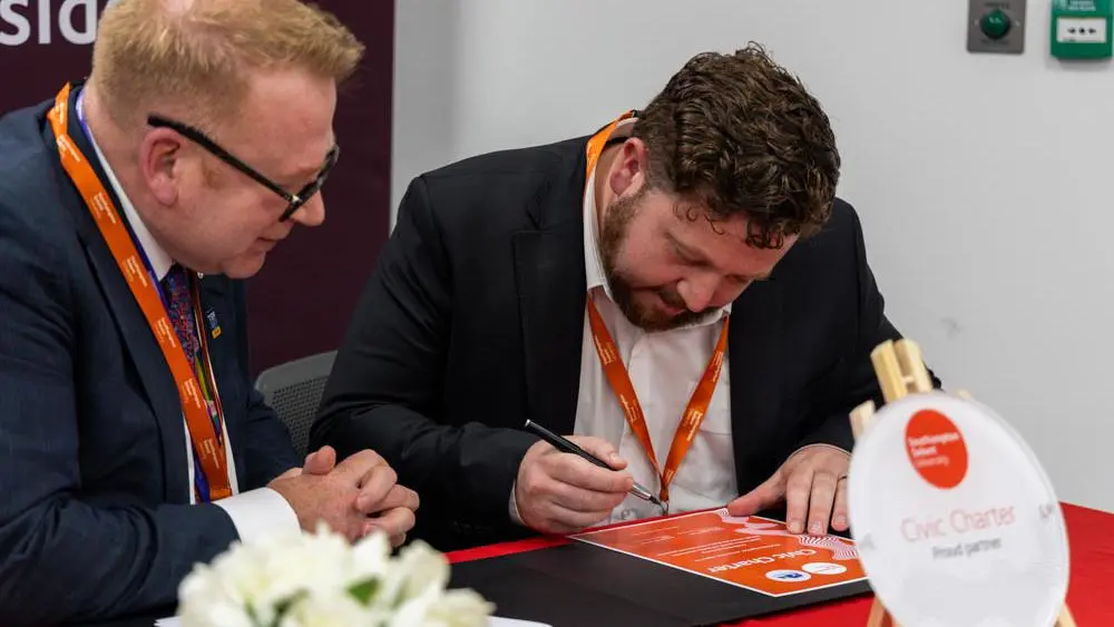 Councillor Alex Winning signs the civic charter