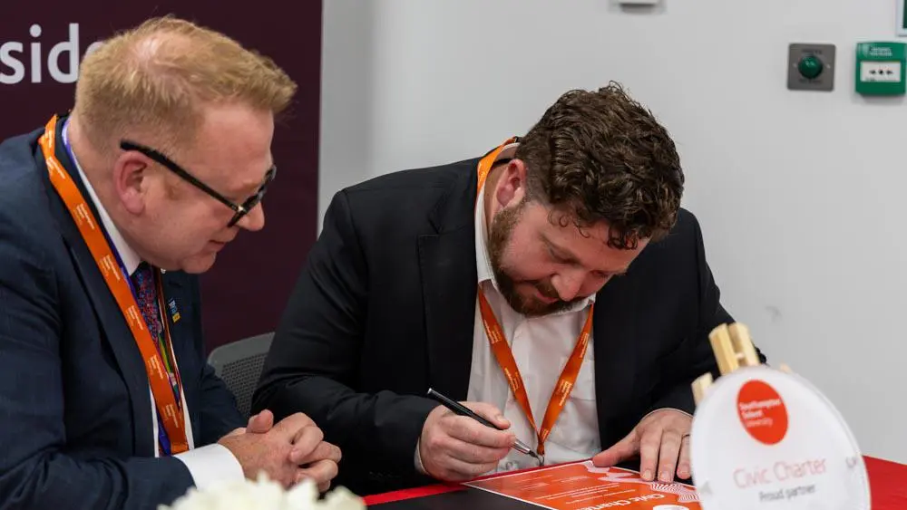 Councillor Alex Winning signs the civic charter