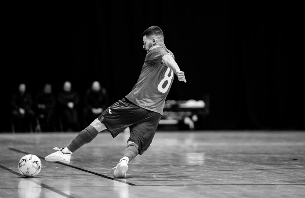 A futsal player kicks a football