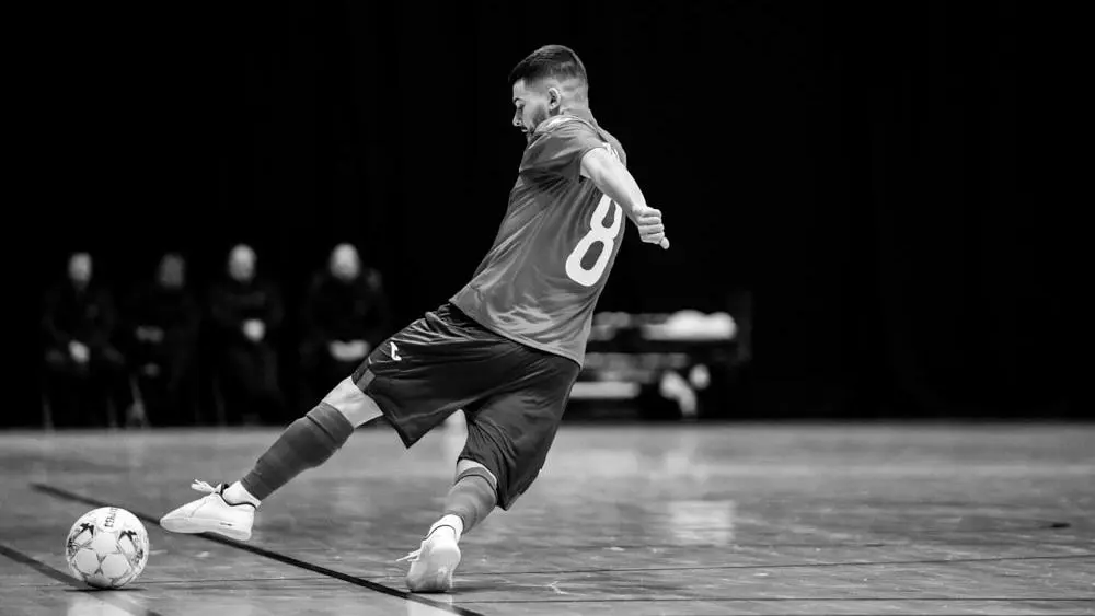 A futsal player kicks a football