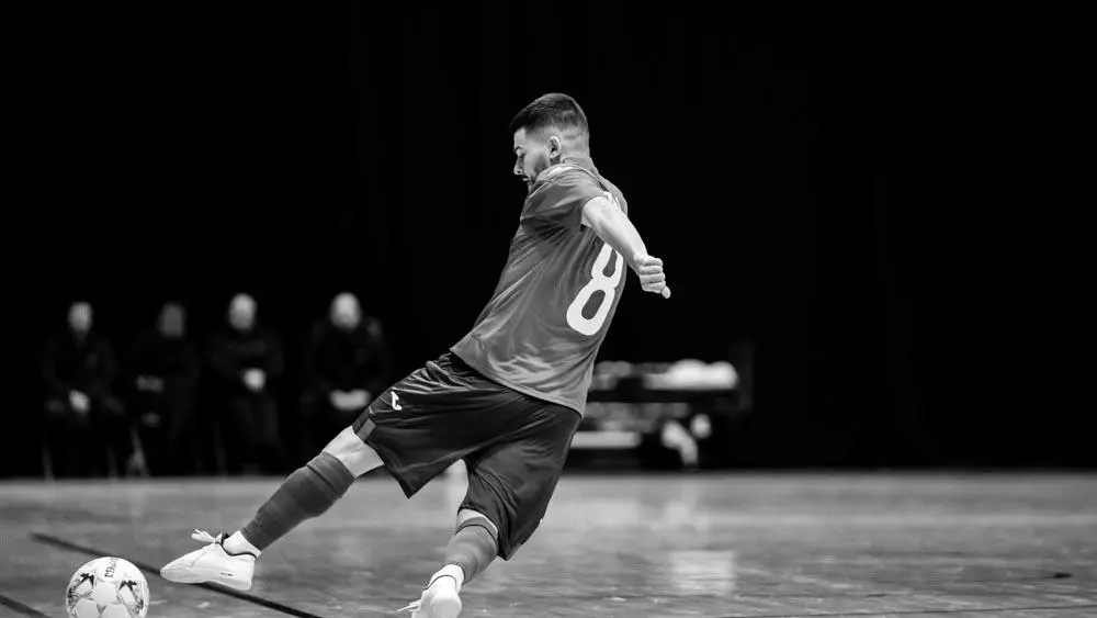 A futsal player kicks a football