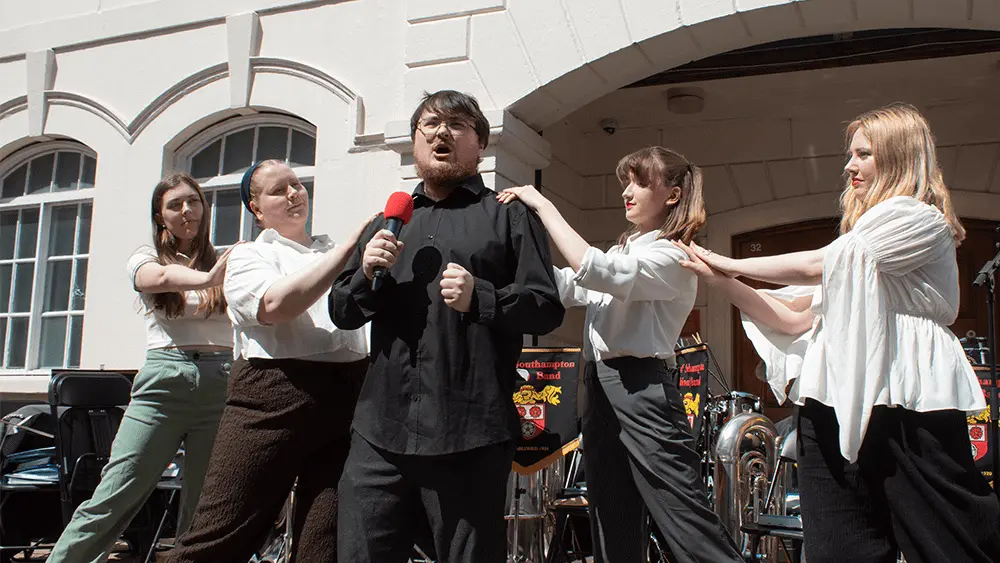 Five students performing outside.