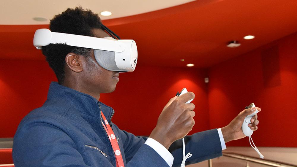 A presenter wearing a VR headset to demonstrate the project's VR simulations