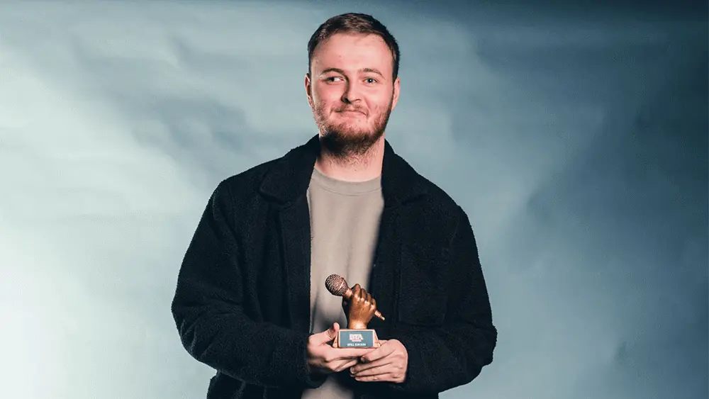 A portrait image of Will Swain holding his trophy.