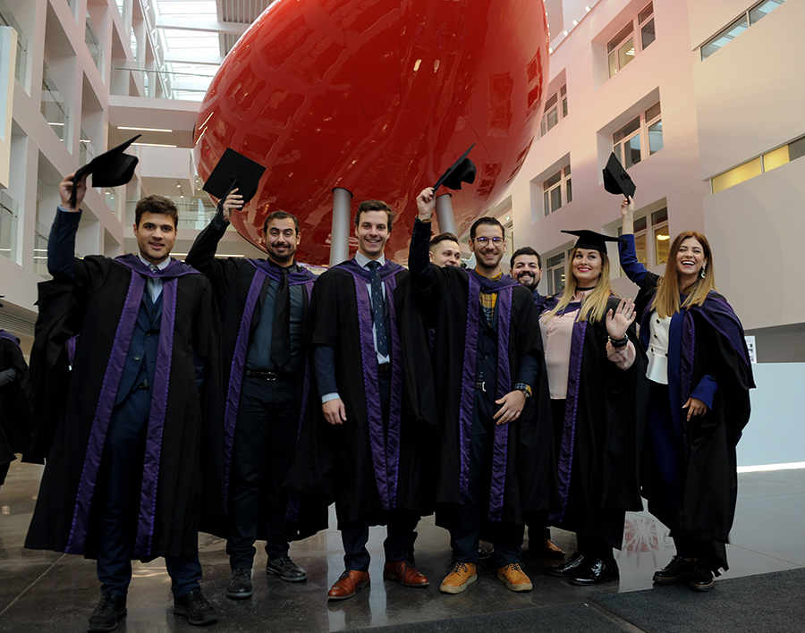 Winter graduates in front of the Pod