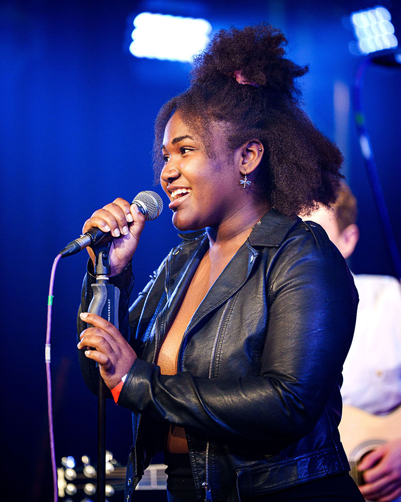 Female performer singing at the mic