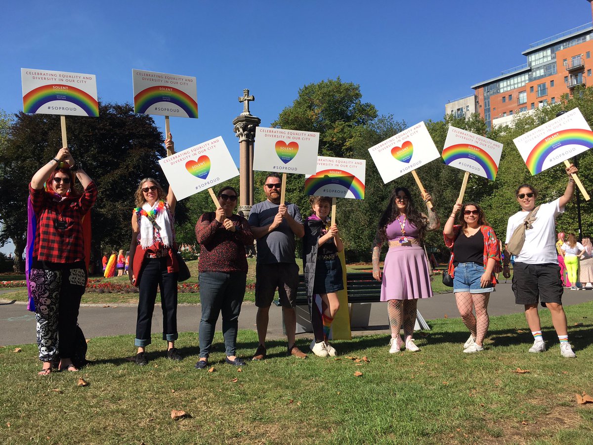 Solent University staff, students and alumni celebrating at Southampton Pride 2022, holding placards as they participated in the Pride march