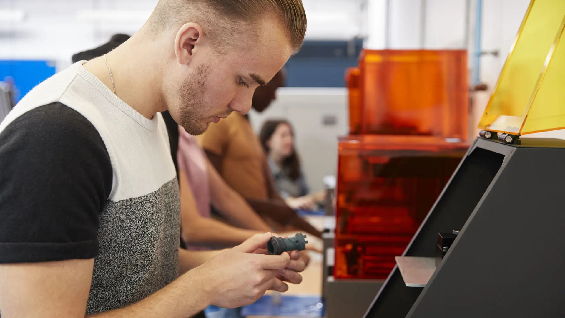 A student with a chess piece in the advanced manufacturing lab