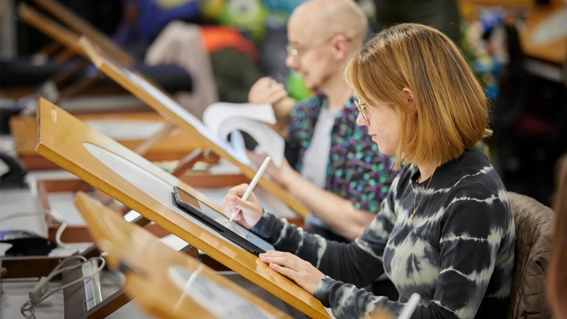 Animation students working on drawing tablets and lightboxes