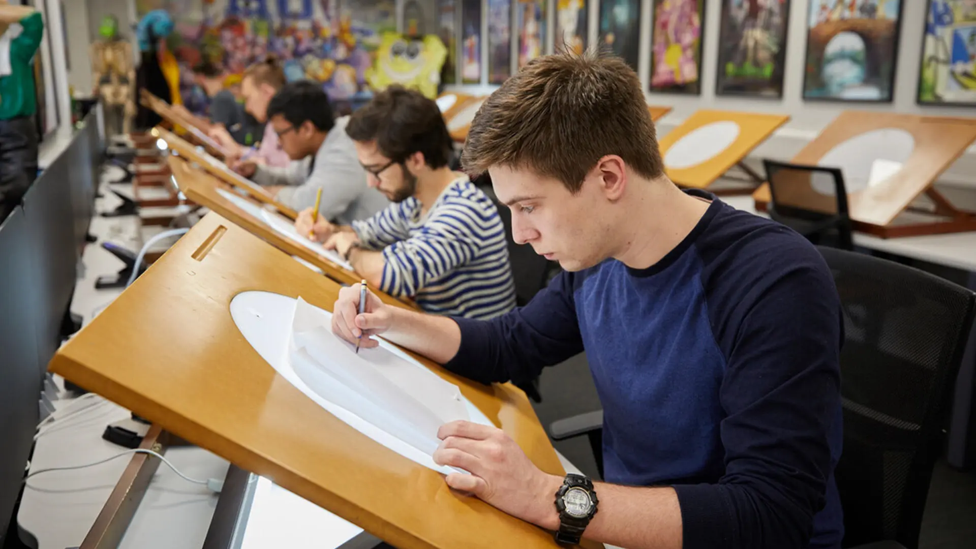 Students in animation studios working on hand-drawn animation using lightboxes