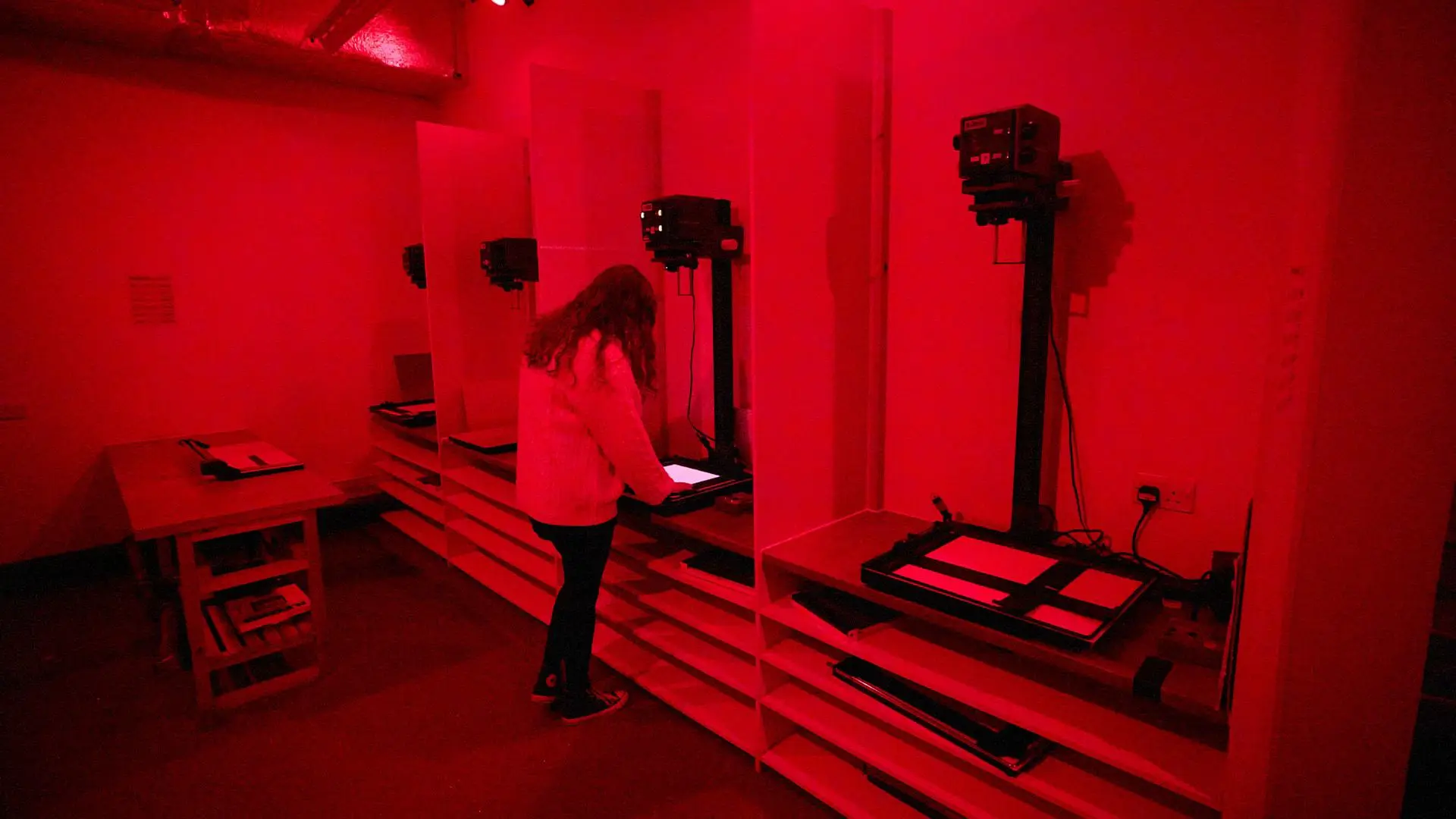 Image inside the photography darkroom, student using an enlarger