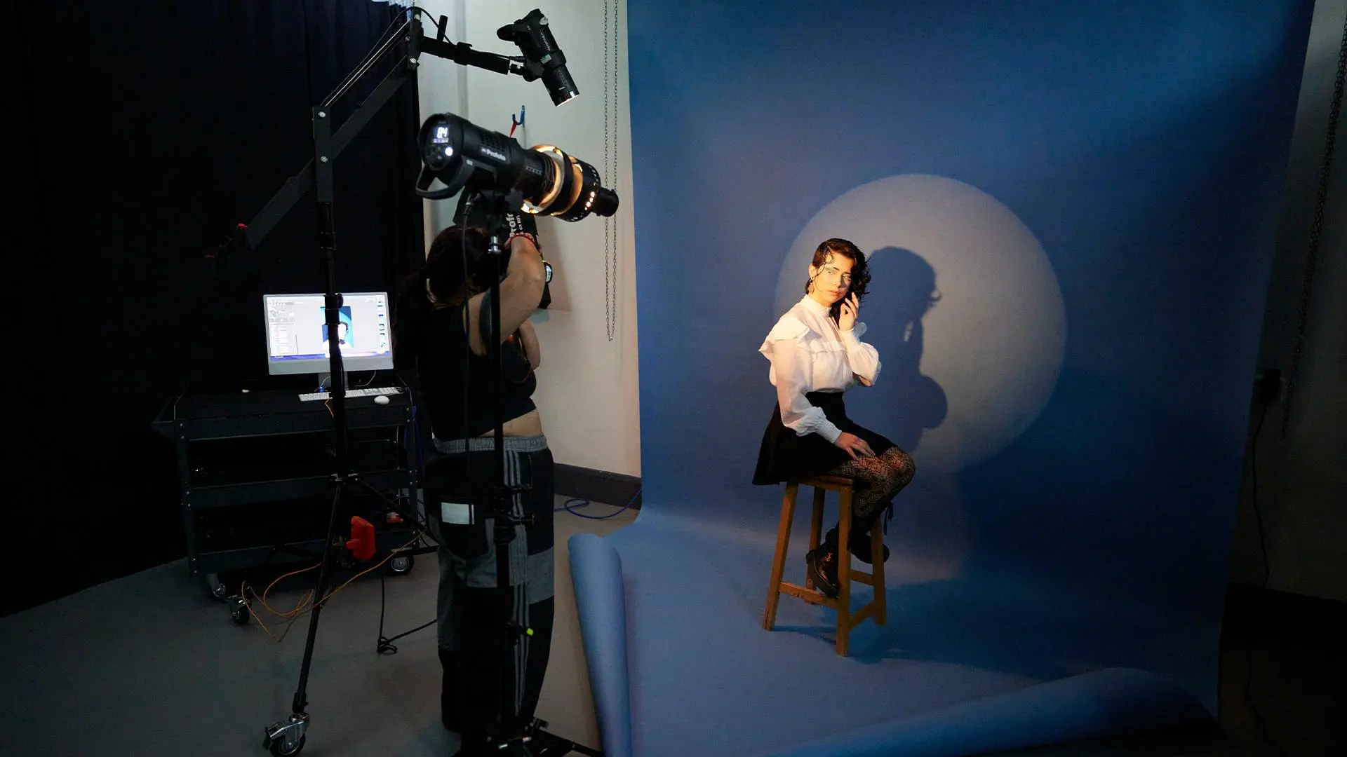 Students working in the main photography studio with a coloured backdrop