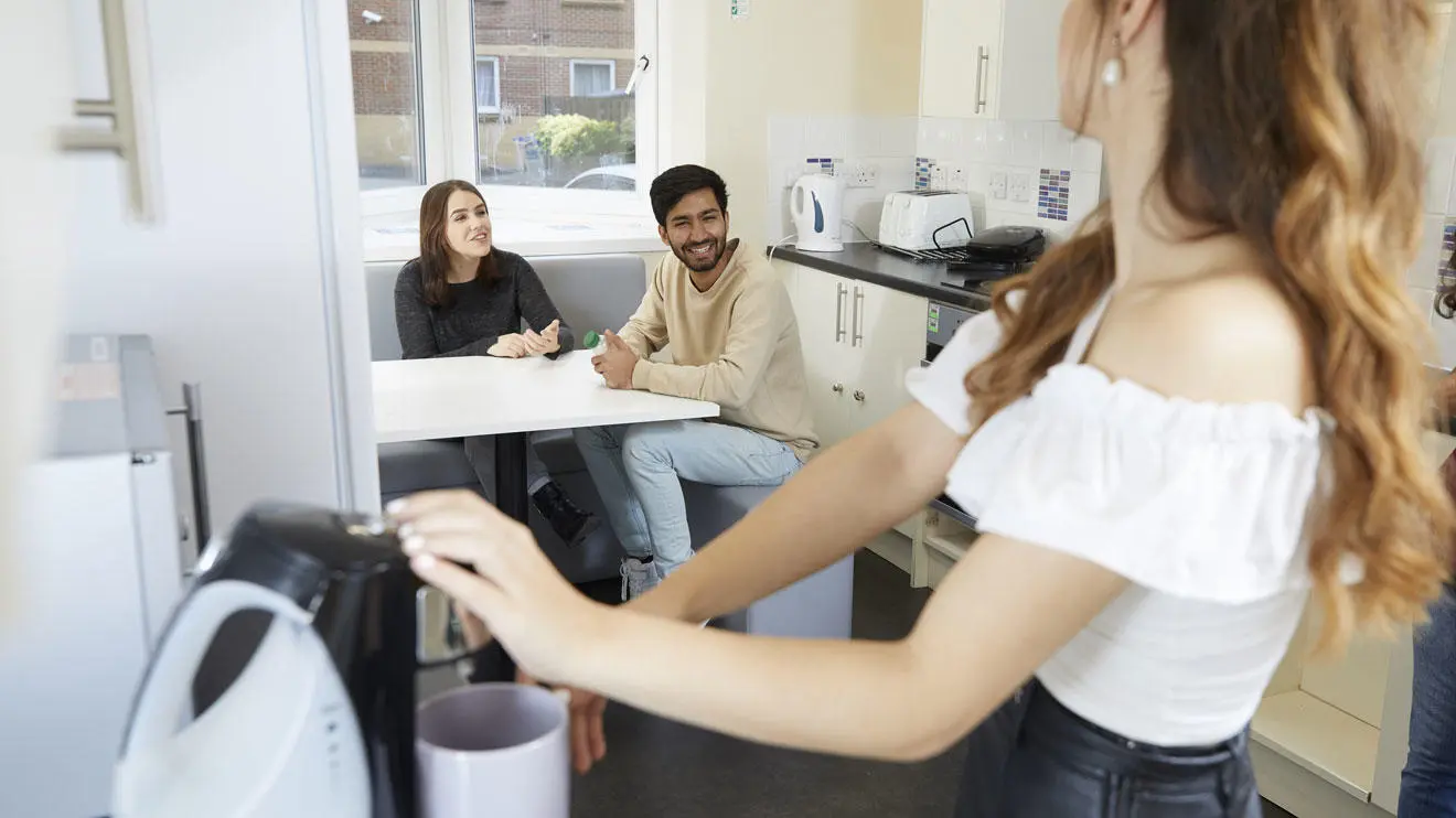 Students making coffee in a kitchen in David Moxon residence