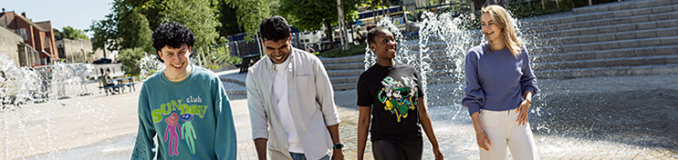Four students walking through Southampton smiling and laughing