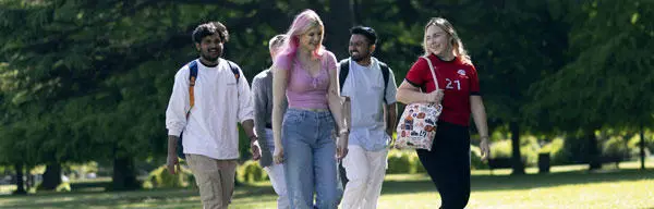 A group of students walking through a park