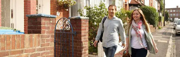 Two students walking along a residential street
