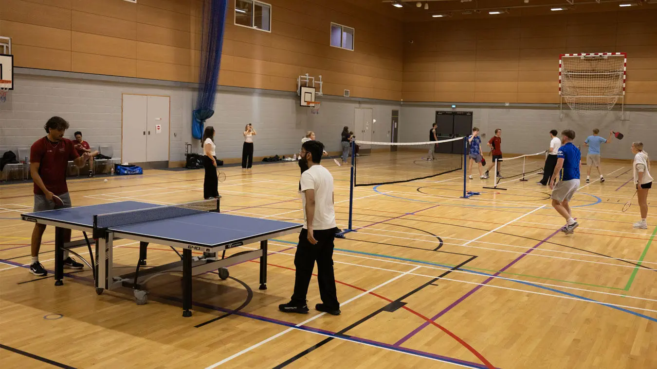 Students playing racket sports in the sports hall