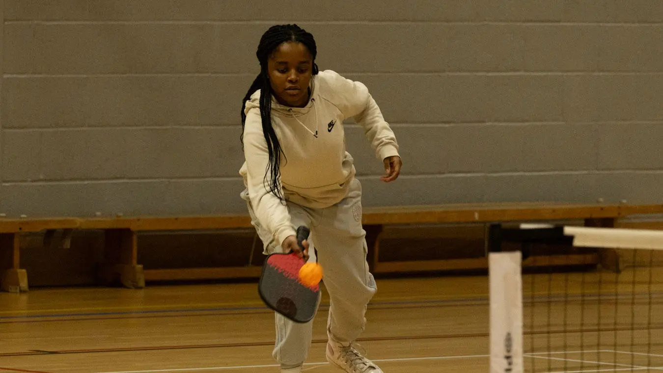 A student playing pickle ball