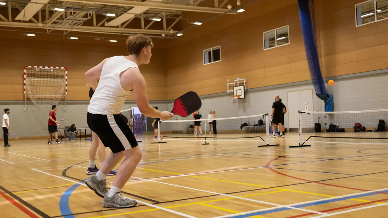Students playing racket sports in the sports hall