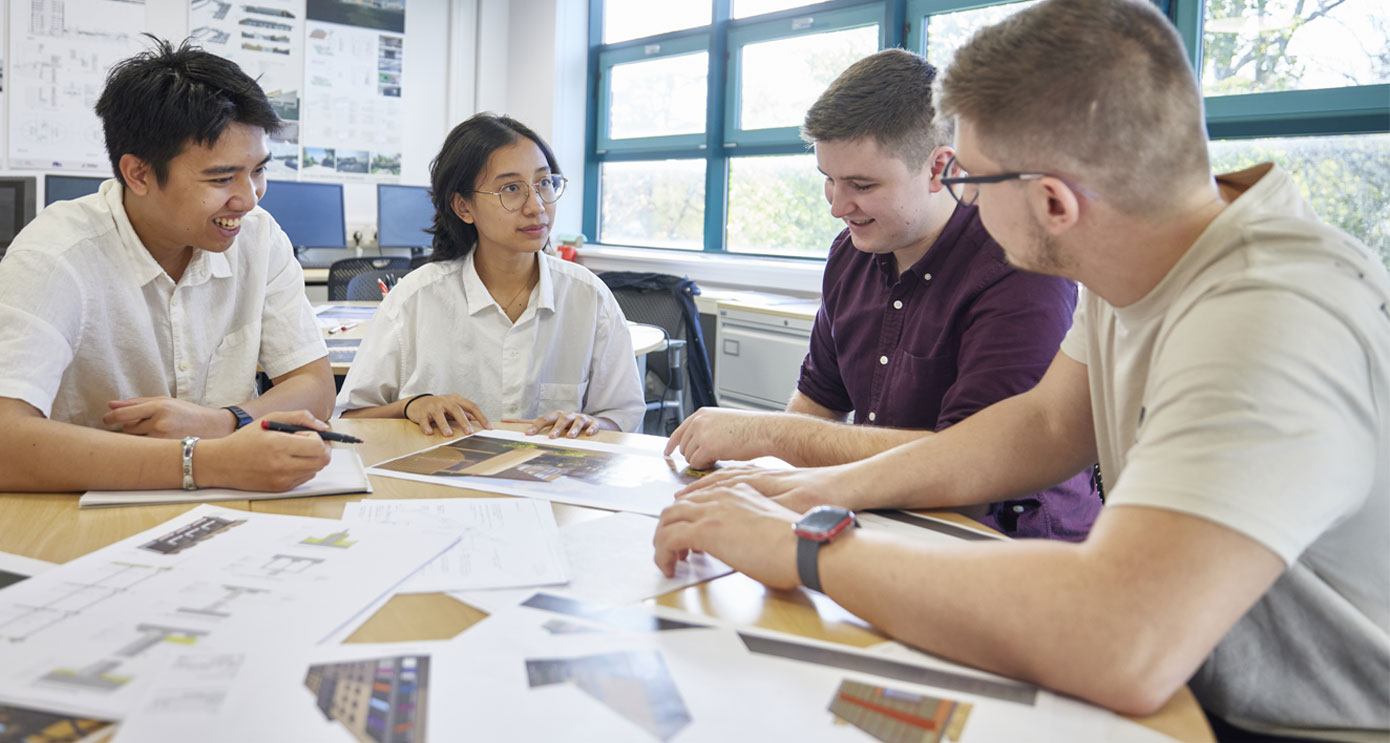 Four architecture students studying drawings