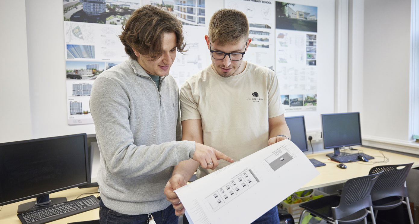Two architecture students looking at drawings